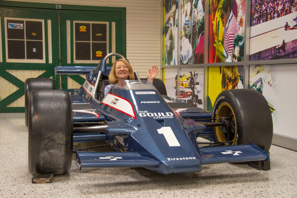 Person in a race car that's used as a photo op in the Indianapolis Motor Speedway Museum