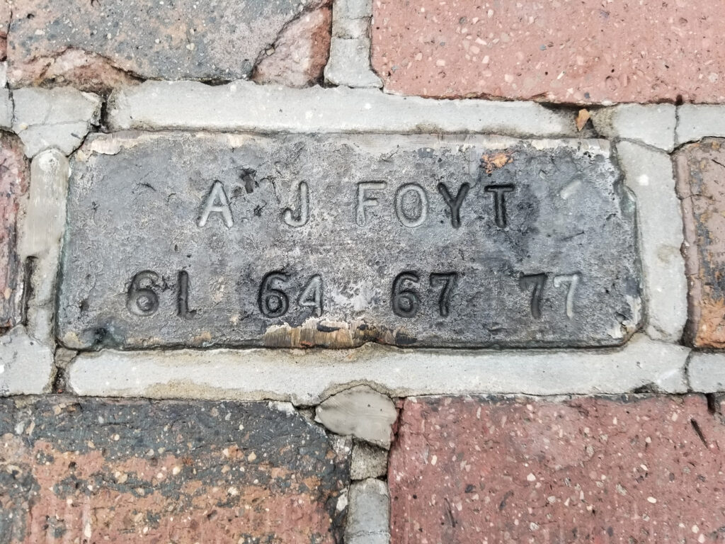 A bronze brick inscribed with A J Foyt and the four years he won the Indy 500: 61, 64, 67, and 77.