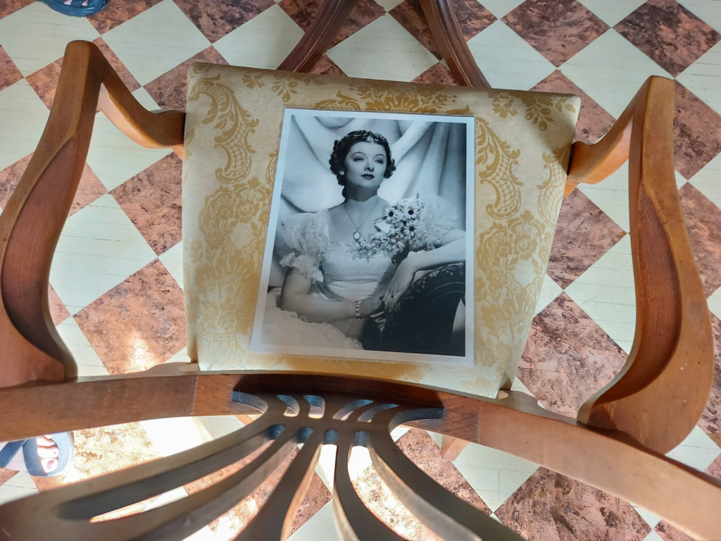 Photo of Myrna Loy resting on a chair