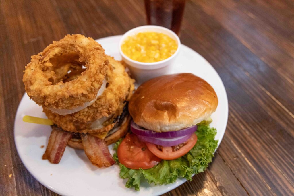 Burger with a large stack of onion rings