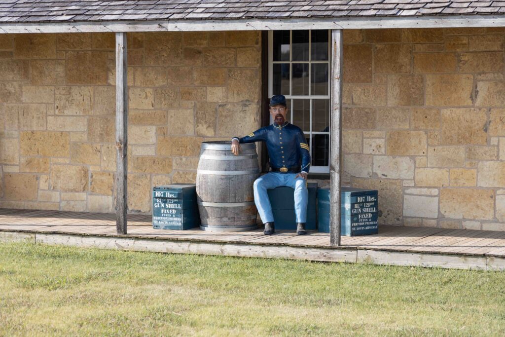 "Guard" mannequin sitting outside the guardhouse at Historic Fort Hays