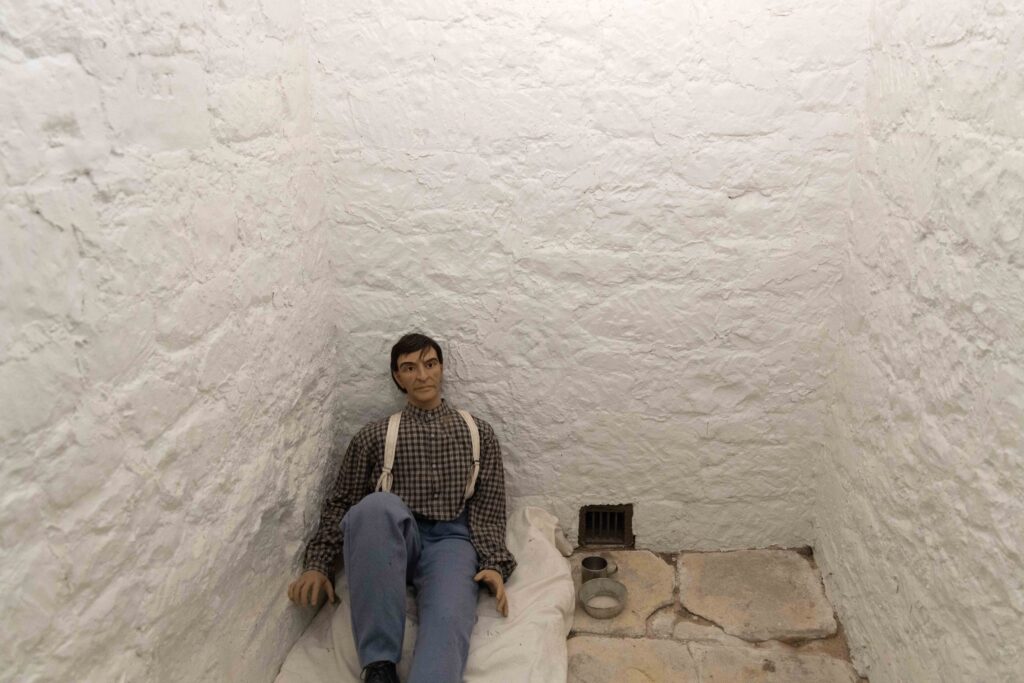 Mannequin sitting on a mattress on a jail cell floor