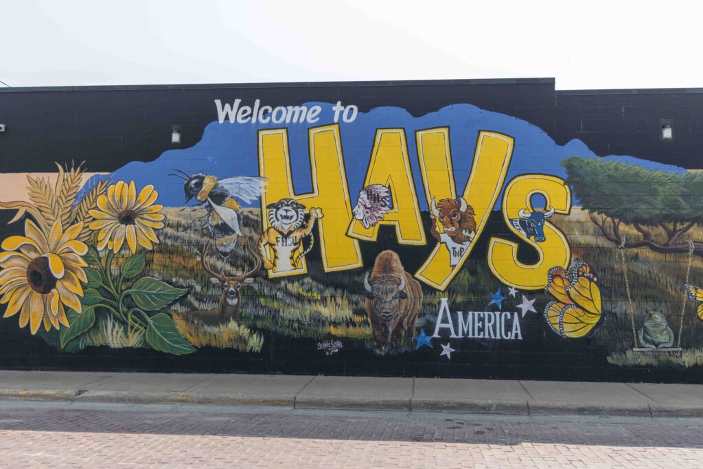 Welcome to Hays mural, with sunflowers, grasses, bison, butterfly, and other animals