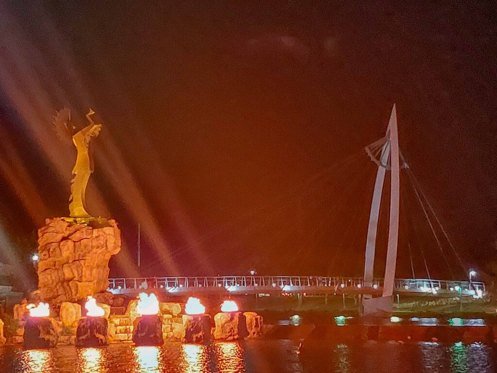 Keeper of the Plains at night with fire rings lit at the base of the statue