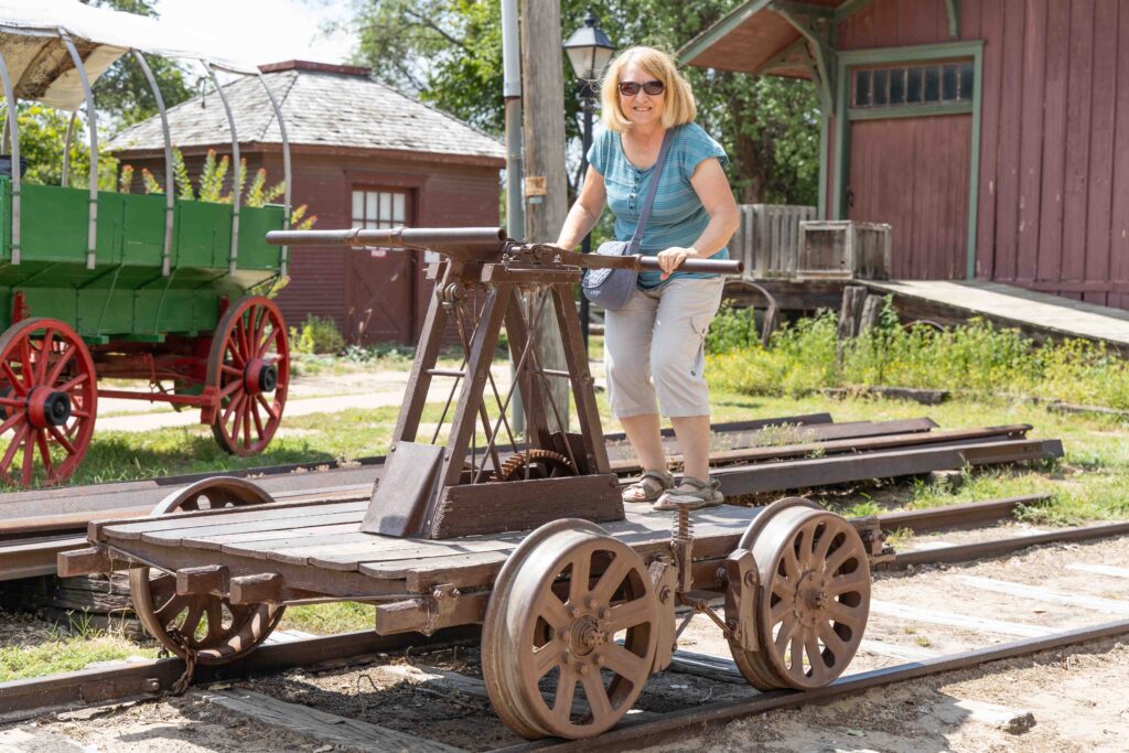 Connie pretending to power a handcar on a railroad track